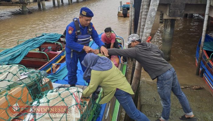 Personel Satpolairud Bantu Penumpang Naik-Turun Kapal di Pelabuhan